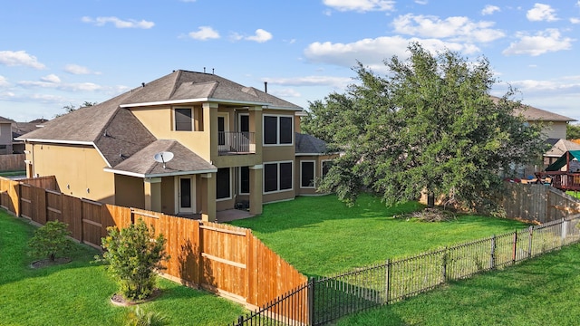 rear view of property with a balcony and a lawn