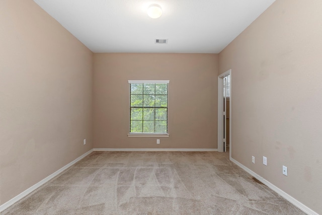 spare room featuring light colored carpet