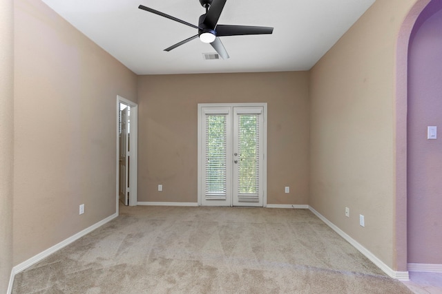 carpeted empty room with french doors and ceiling fan