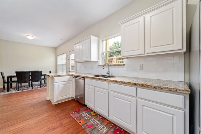 kitchen with backsplash, appliances with stainless steel finishes, light hardwood / wood-style floors, white cabinetry, and sink