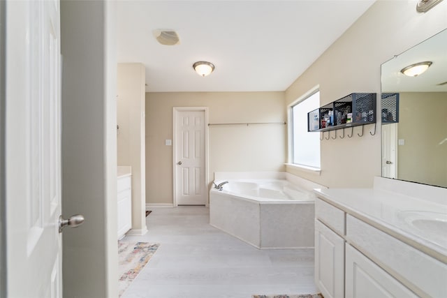 bathroom featuring wood-type flooring, vanity, and a bathtub