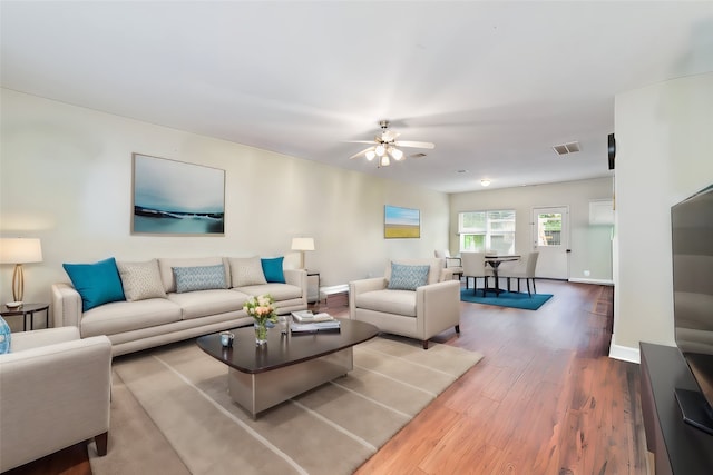 living room featuring wood-type flooring and ceiling fan