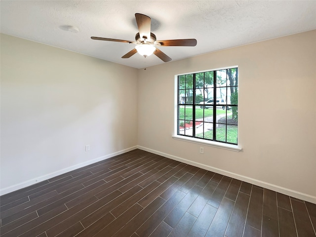 unfurnished room featuring a textured ceiling, plenty of natural light, ceiling fan, and dark wood-type flooring