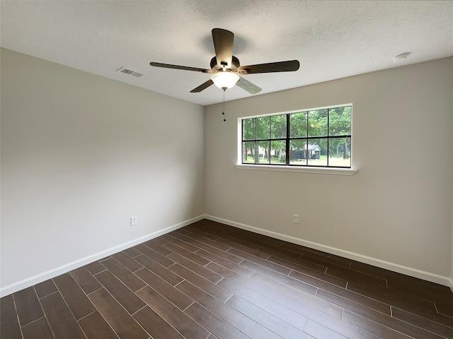 empty room featuring dark hardwood / wood-style flooring, ceiling fan, and a textured ceiling