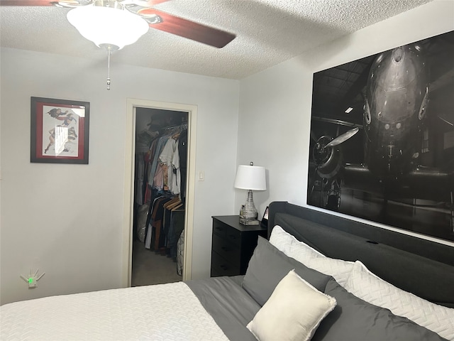 bedroom featuring a closet, a spacious closet, ceiling fan, and a textured ceiling