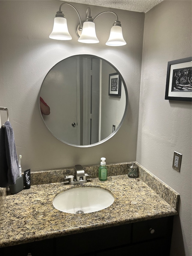 bathroom with vanity with extensive cabinet space and a textured ceiling