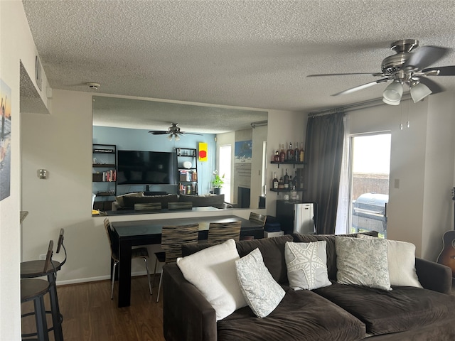 living room with ceiling fan, hardwood / wood-style flooring, and a textured ceiling