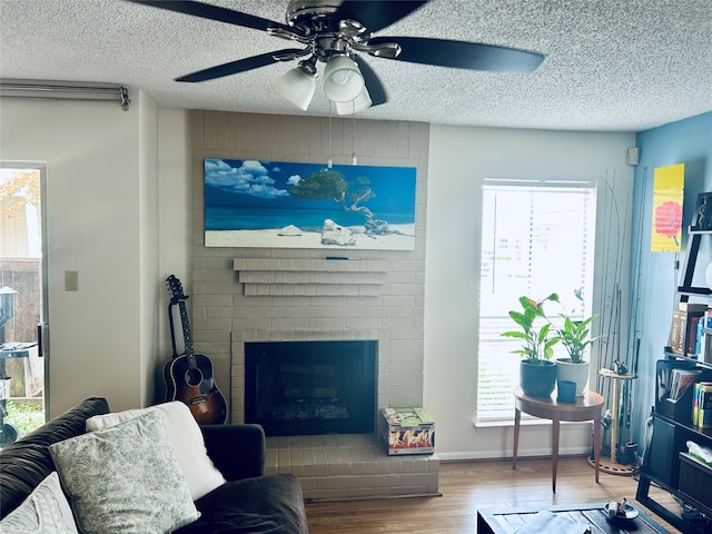 living room with hardwood / wood-style floors, a fireplace, a wealth of natural light, and a textured ceiling