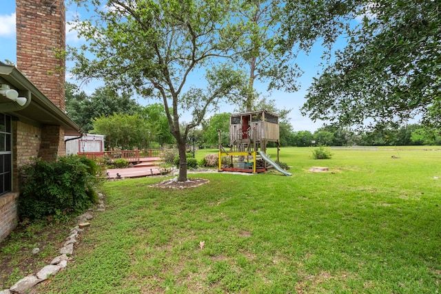 view of yard with a playground and a wooden deck