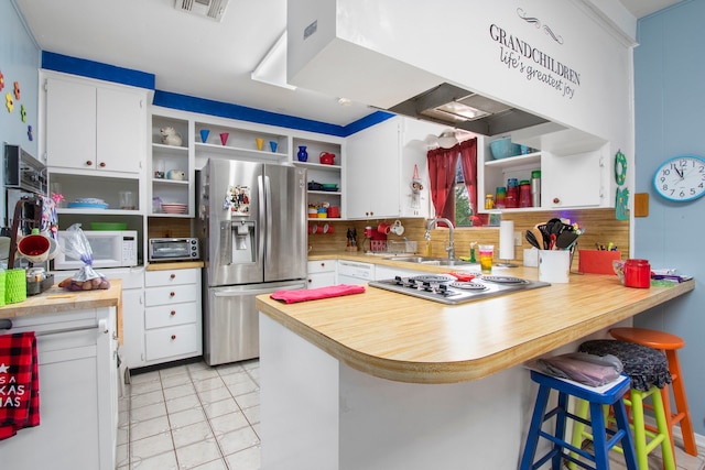 kitchen featuring white cabinetry, kitchen peninsula, appliances with stainless steel finishes, sink, and light tile floors