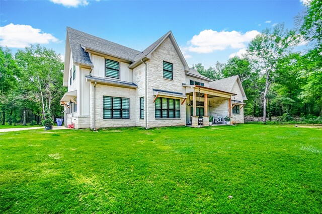 rear view of house featuring a lawn