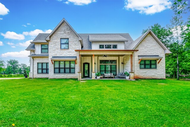 view of front of house with ceiling fan, a patio, and a front lawn