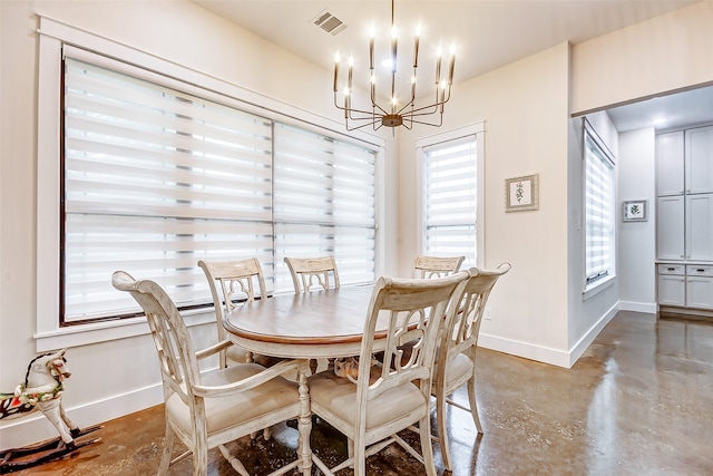 dining area with an inviting chandelier and concrete floors