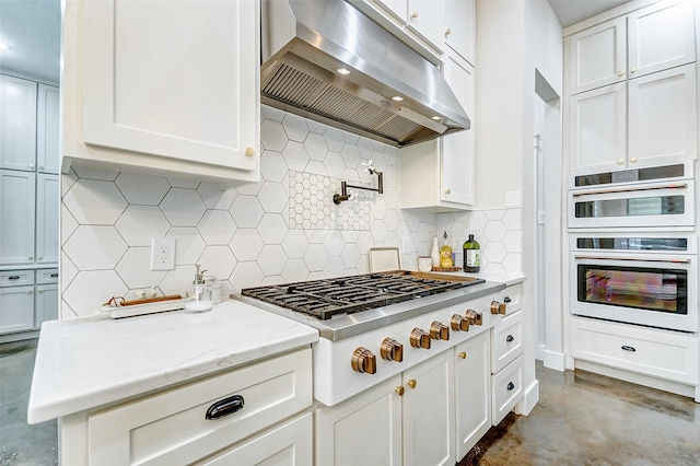 kitchen with backsplash, double oven, white cabinets, and gas stovetop