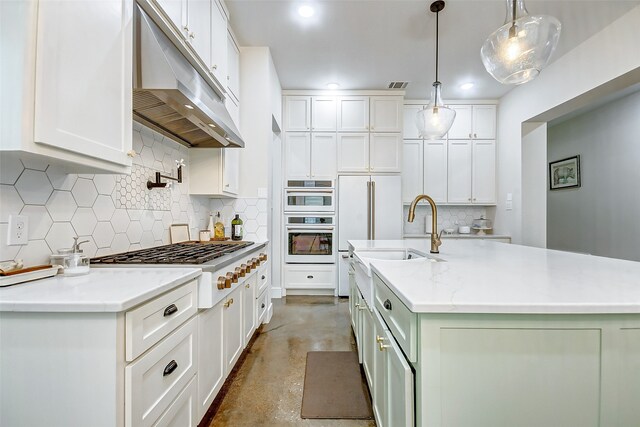 kitchen featuring stainless steel appliances, tasteful backsplash, an island with sink, white cabinetry, and pendant lighting