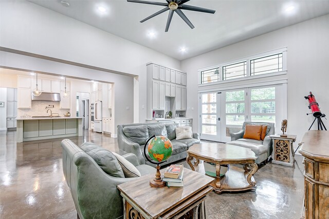 living room featuring a towering ceiling, ceiling fan, and sink