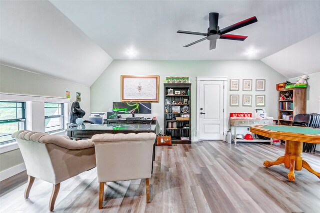 living room with light hardwood / wood-style flooring, ceiling fan, and vaulted ceiling