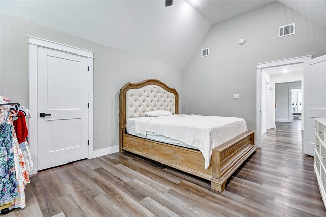 bedroom featuring hardwood / wood-style flooring and high vaulted ceiling