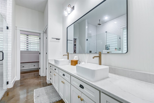 bathroom featuring concrete flooring, a shower with shower door, and double vanity