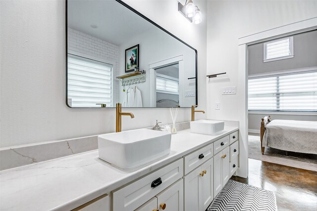 bathroom featuring concrete floors, vanity with extensive cabinet space, and dual sinks