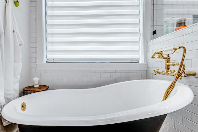 bathroom with a bath and tile walls