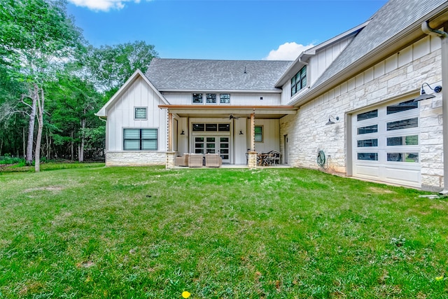 rear view of house with a garage, a lawn, and ceiling fan