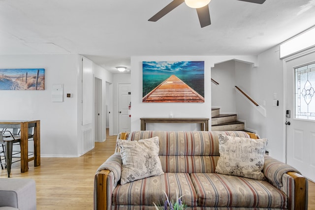 living room with light wood-type flooring and ceiling fan