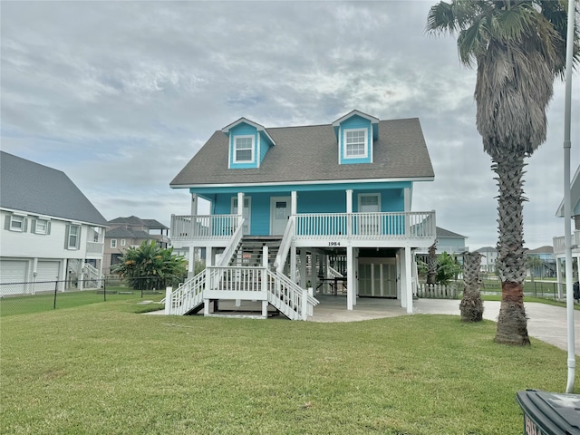 back of property with a porch, a yard, and a carport