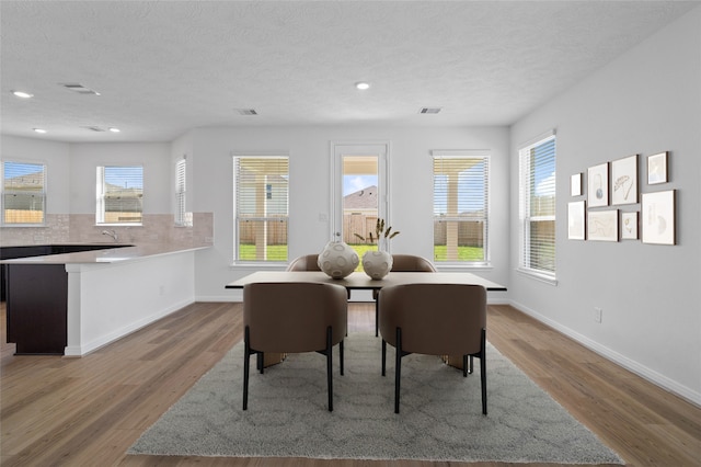 dining room with a textured ceiling and light wood-type flooring