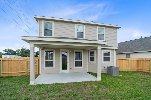 back of house featuring a yard, central AC unit, and a patio area