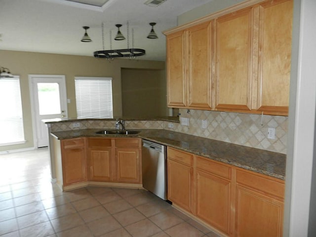 kitchen featuring light tile floors, sink, tasteful backsplash, dark stone counters, and dishwasher