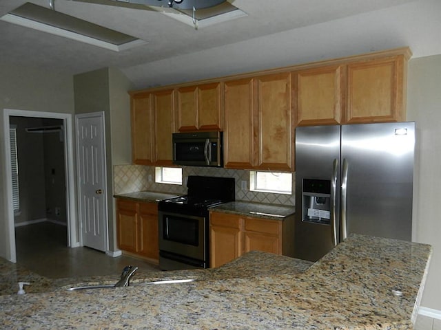 kitchen featuring light stone counters, appliances with stainless steel finishes, tasteful backsplash, and kitchen peninsula