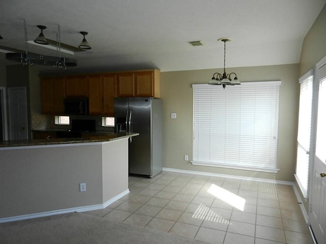 kitchen featuring hanging light fixtures, stainless steel refrigerator with ice dispenser, a chandelier, light tile floors, and tasteful backsplash