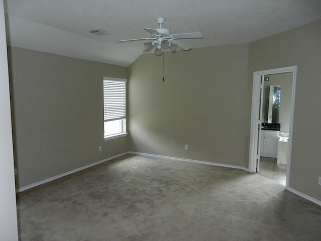 interior space featuring vaulted ceiling, connected bathroom, ceiling fan, and carpet floors