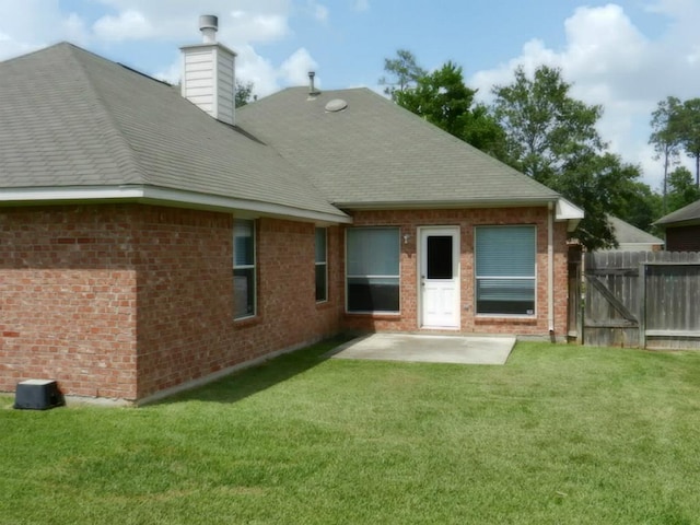 rear view of house with a lawn and a patio area