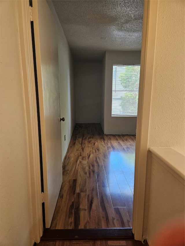 hallway featuring a textured ceiling and hardwood / wood-style flooring