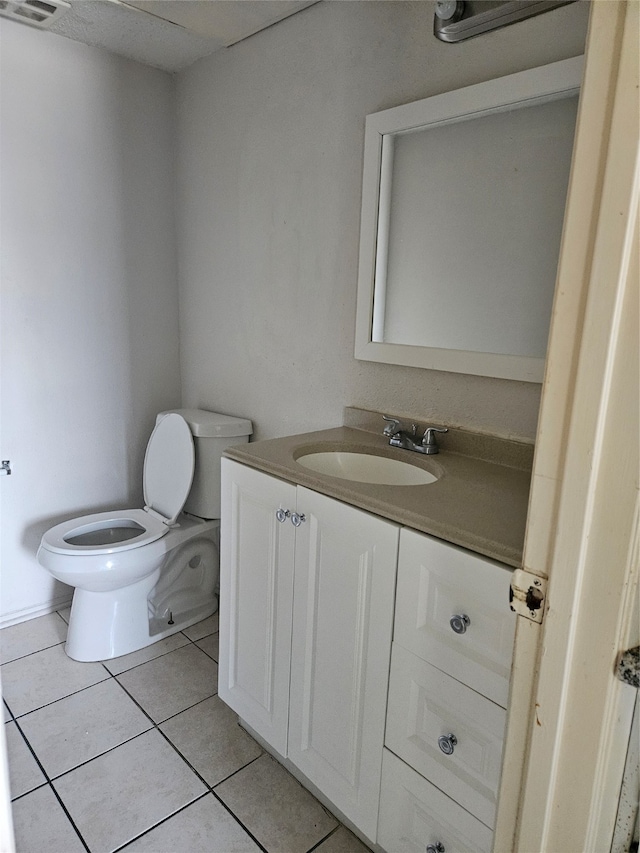 bathroom with tile flooring, vanity, and toilet