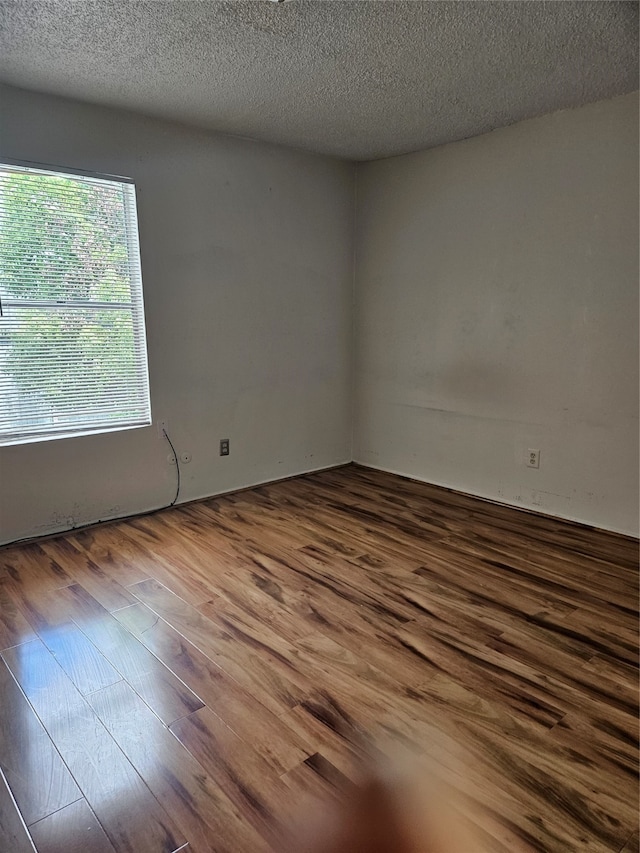 empty room featuring hardwood / wood-style floors and a textured ceiling