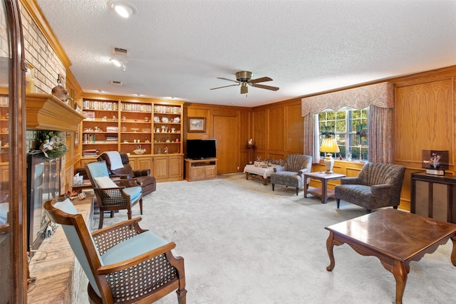 living room featuring ceiling fan, a textured ceiling, light colored carpet, brick wall, and crown molding