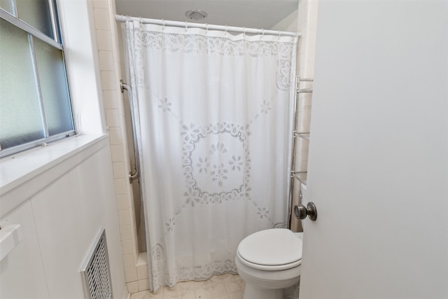 bathroom with tile flooring and toilet