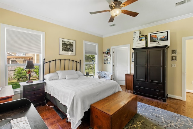 bedroom with crown molding, dark wood-type flooring, and ceiling fan