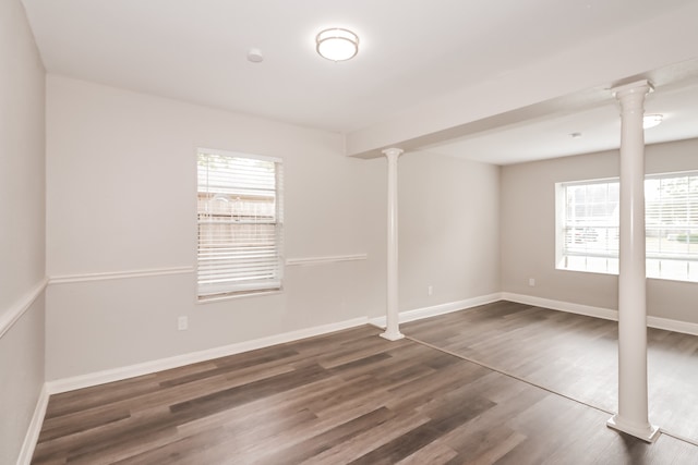 spare room with dark hardwood / wood-style floors and ornate columns