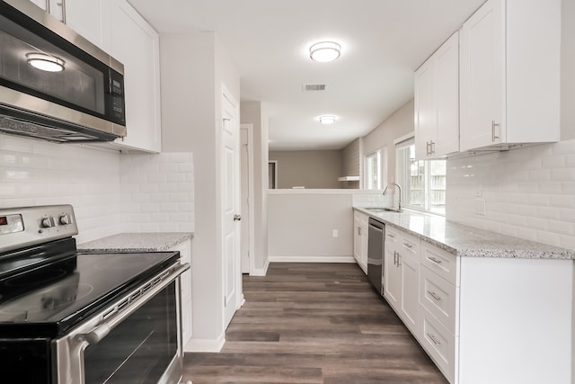 kitchen with backsplash, stainless steel appliances, dark hardwood / wood-style flooring, and white cabinetry