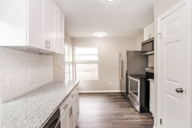 kitchen featuring white cabinets, light stone countertops, dark hardwood / wood-style floors, stainless steel appliances, and tasteful backsplash