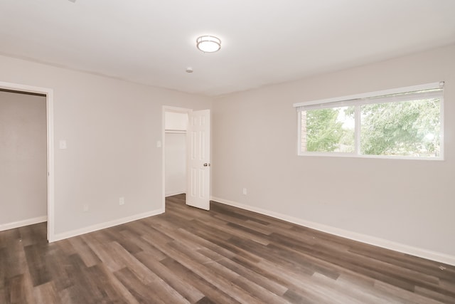 unfurnished room with dark wood-type flooring