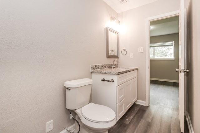 bathroom featuring vanity, toilet, and hardwood / wood-style flooring