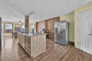 kitchen featuring stainless steel fridge, rail lighting, a kitchen island, and dark wood-type flooring