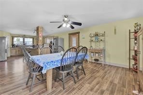 dining space featuring wood-type flooring and ceiling fan