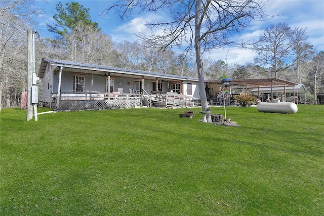 back of house featuring covered porch and a yard