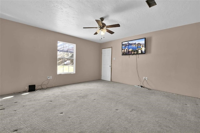 carpeted empty room with ceiling fan and a textured ceiling